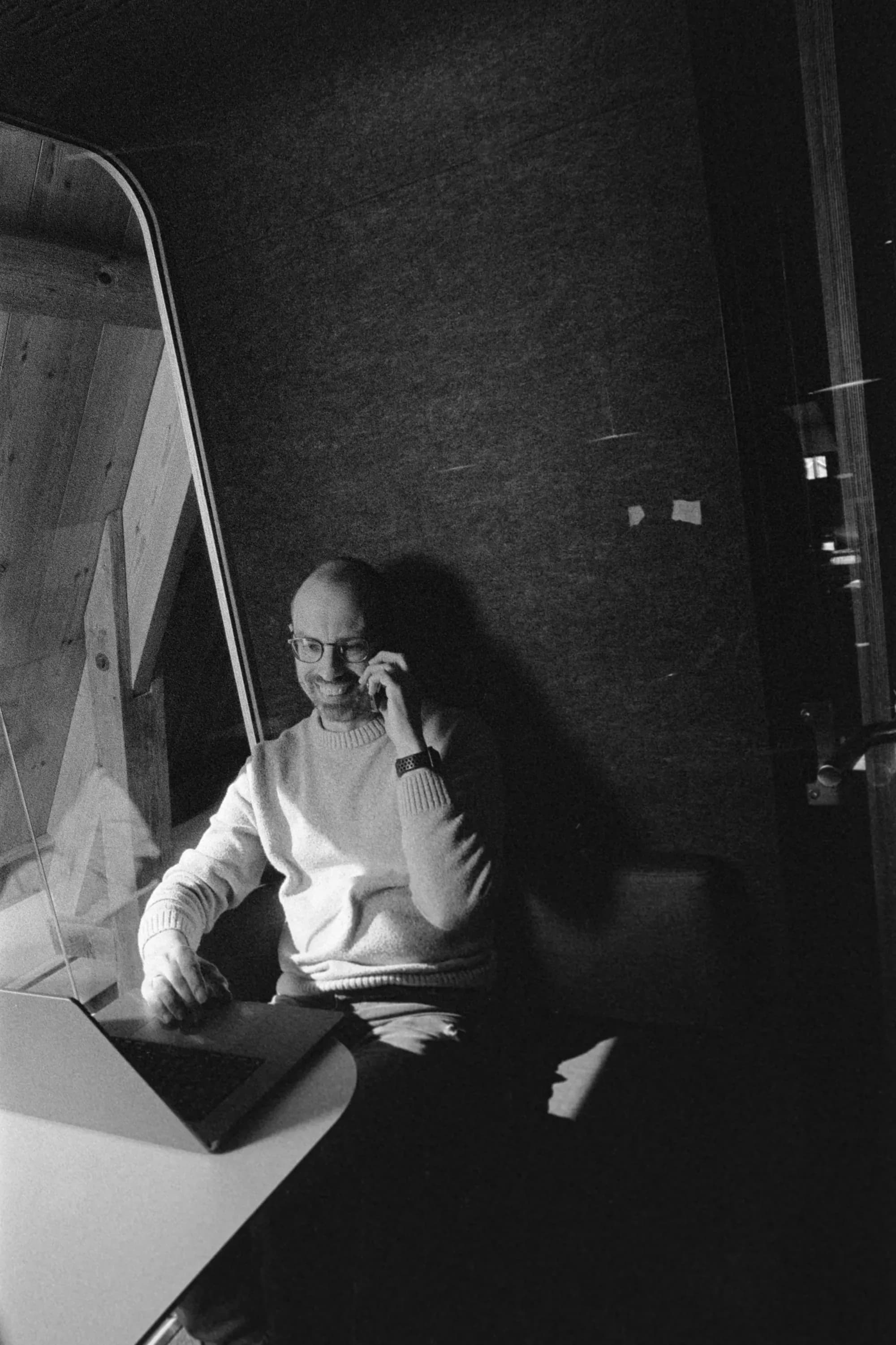 Colleague calling on his phone behind his laptop