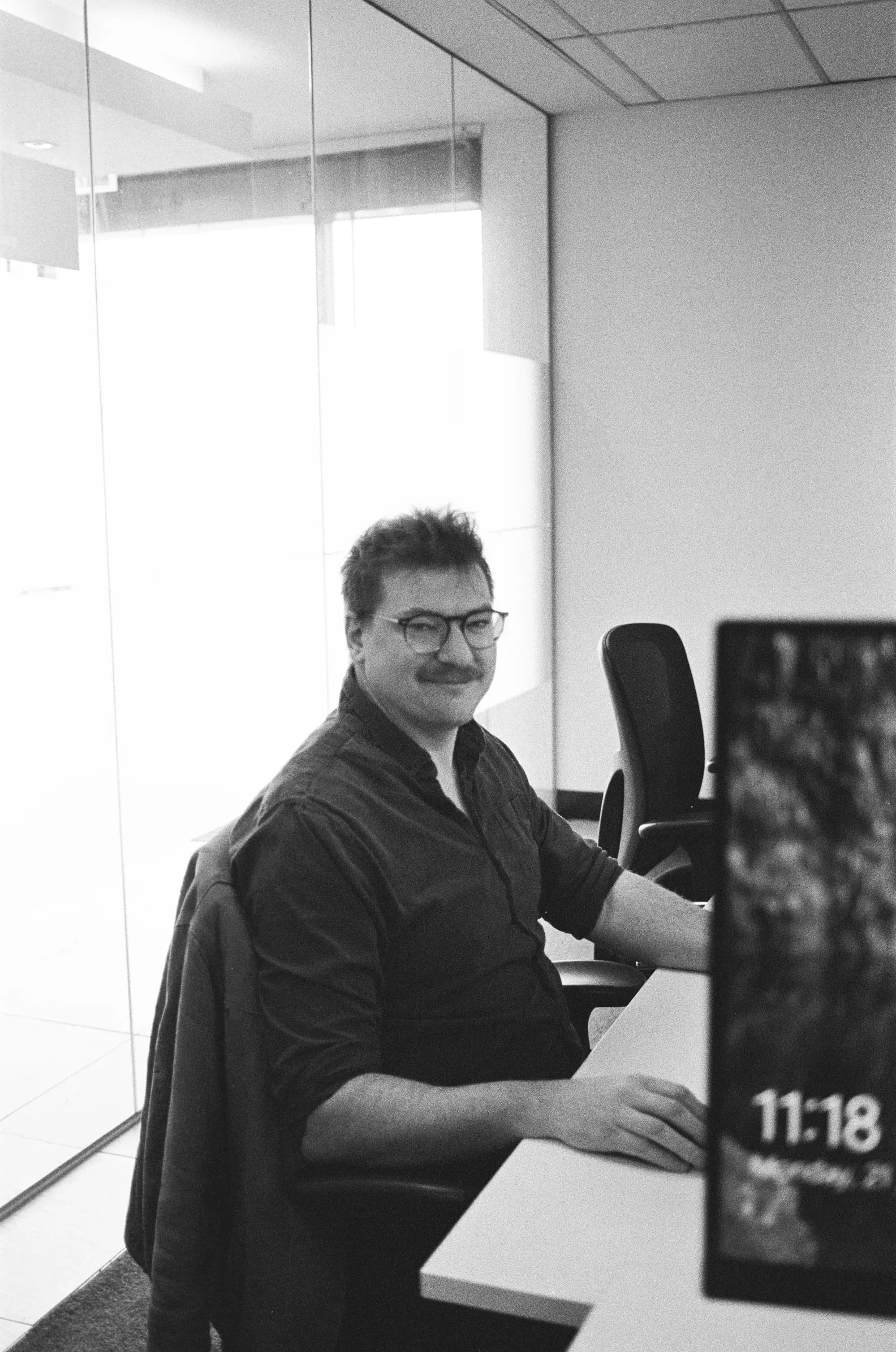 Colleague on computer, smiling at camera