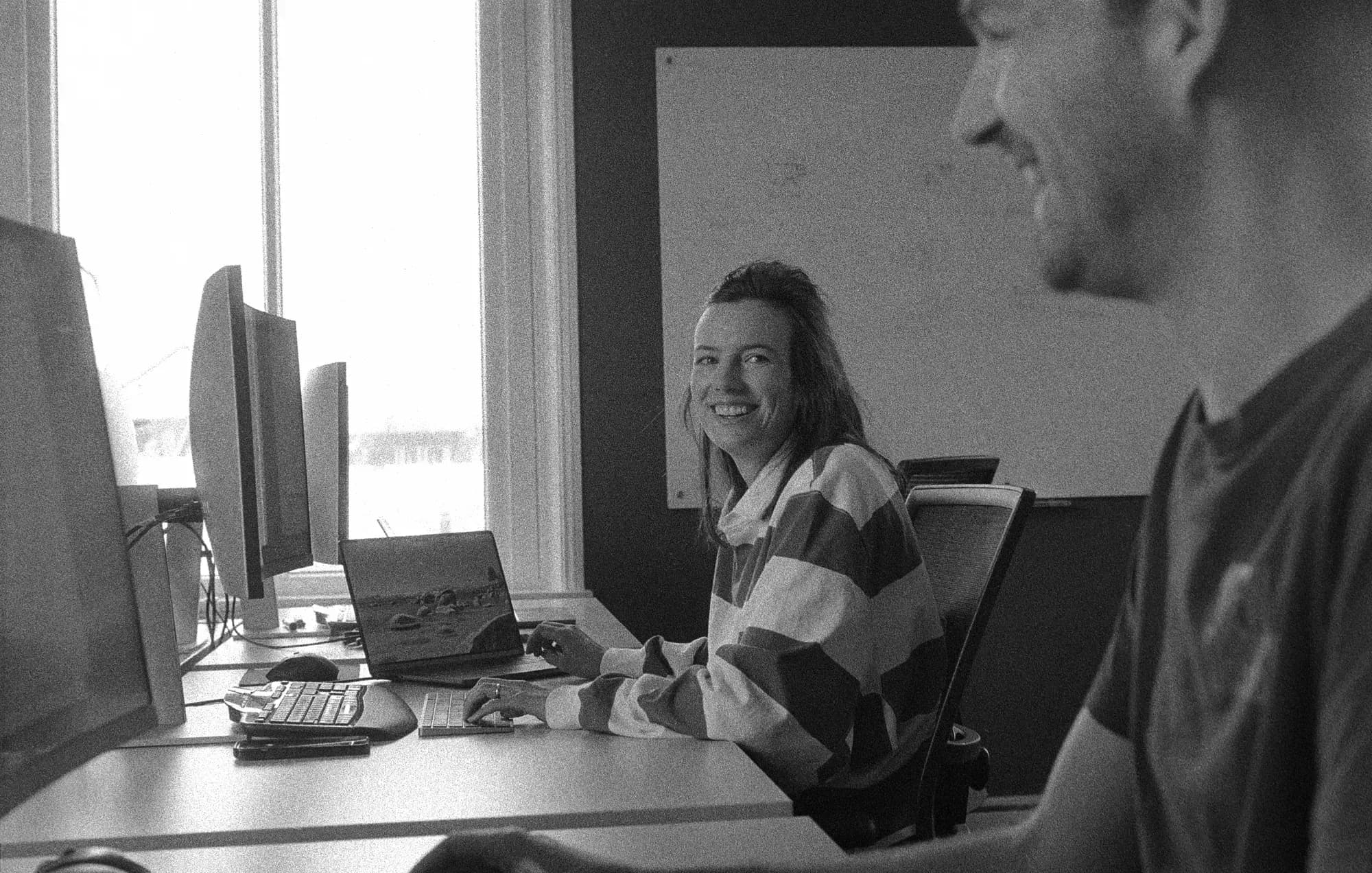 Twee collega’s kijken elkaar lachend aan