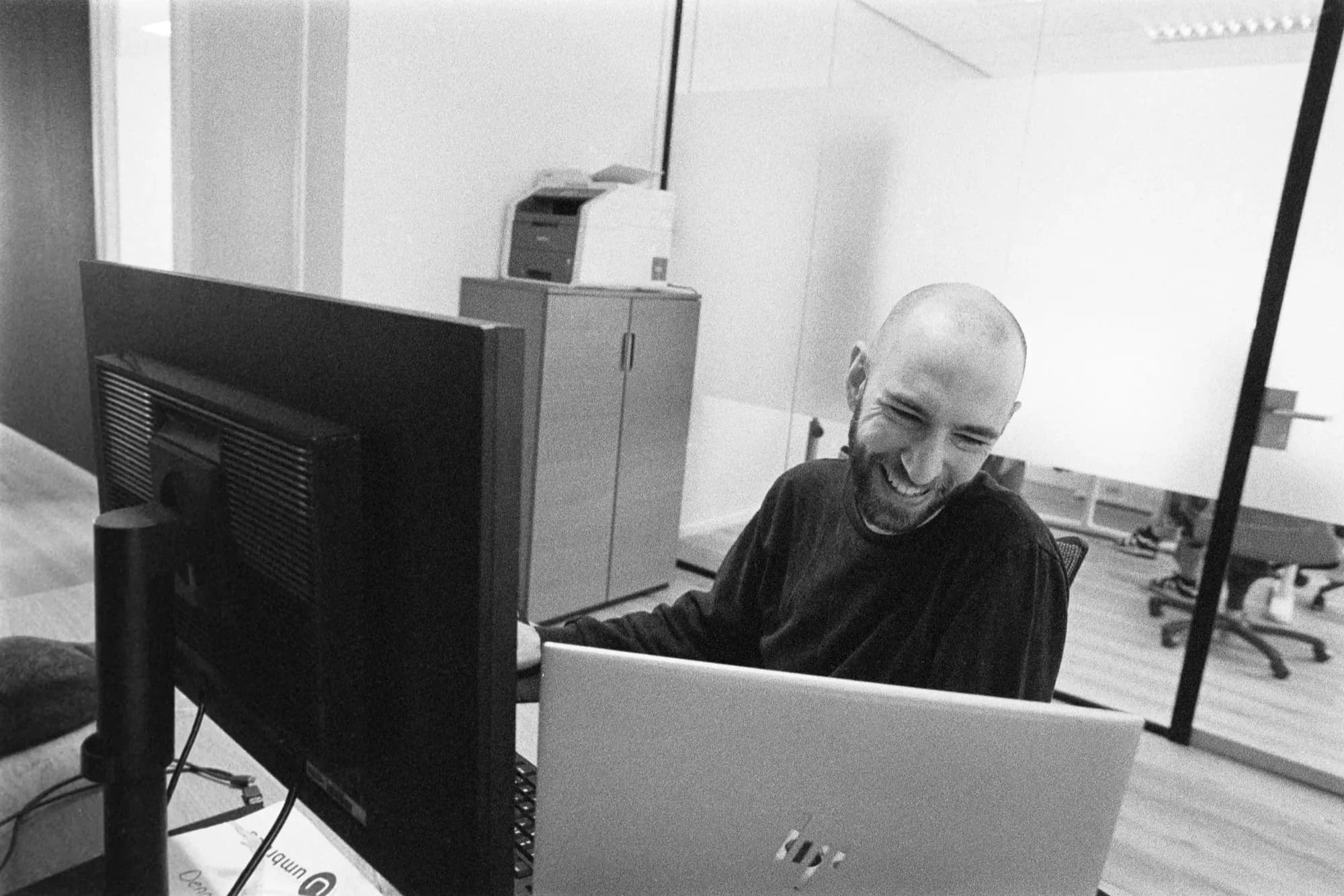 Collega lachend achter zijn computer